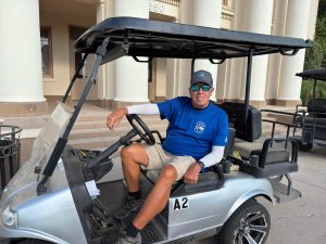 Norman Knox poses for a portrait with his golf cart in front of Old Main at Chandler High School on August 7, 2025.