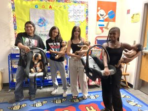 From left to right: Early Childhood Development students Abrian Rico, Kayla Hawel, Savanah Barclay, and Lysis Hills hold their robotic dolls at Chandler High School on August 20, 2025.