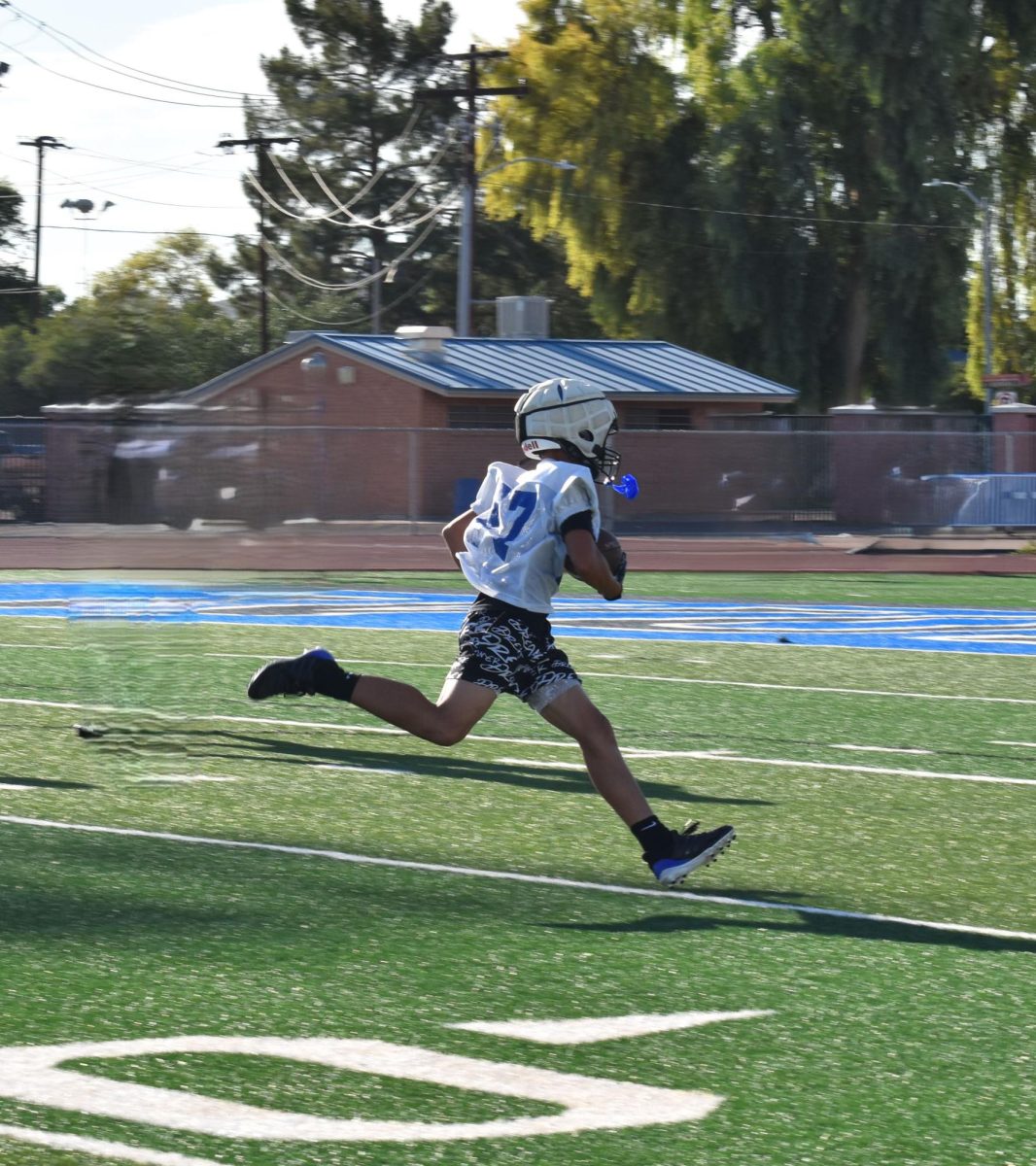 A CHS football player runs with the ball during a morning practice.
